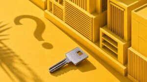 Visible silver key beside yellow architectural model and question mark shadow representing Singapore property decisions